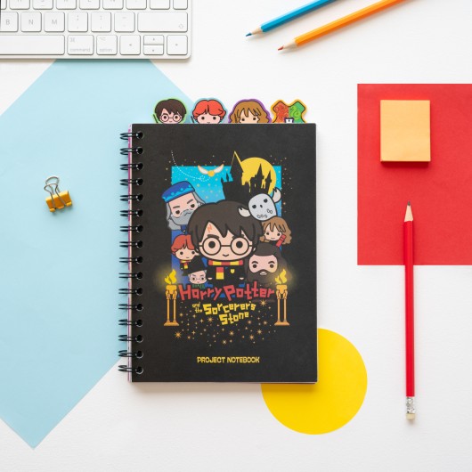 Caderno Harry Potter sobre uma mesa com materiais escolares e separadores visíveis.