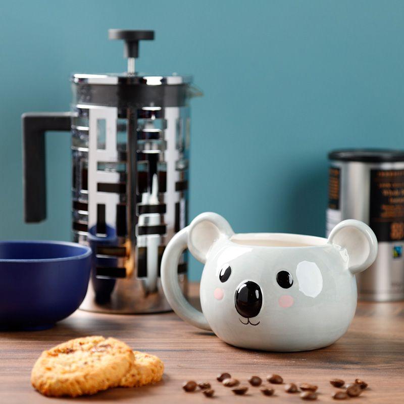 Caneca engraçada de koala num ambiente de café, complementando perfeitamente qualquer decoração de cozinha.