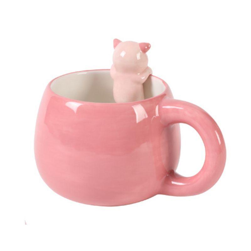 Vista lateral da caneca rosa com figura de porquinho no interior voltada para o lado.