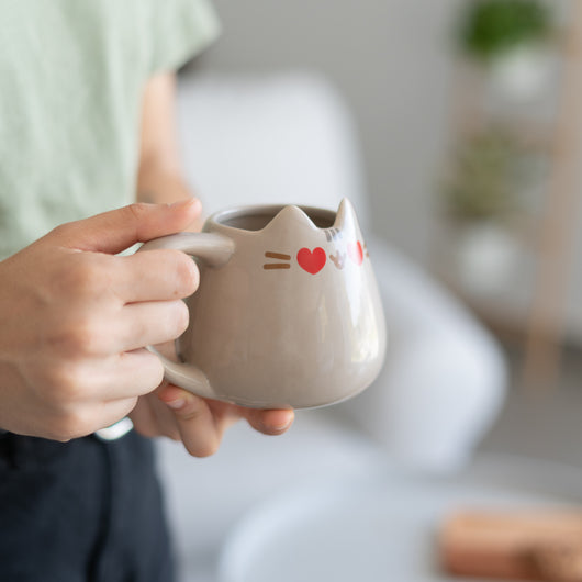 Pessoa a segurar a Caneca Pusheen 3D com expressão fofa e detalhes adoráveis.