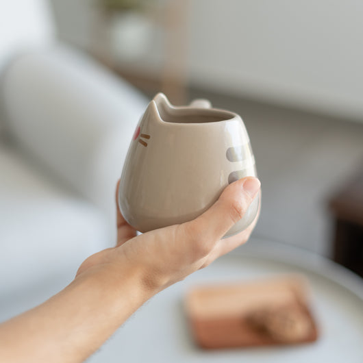 Caneca Pusheen 3D sendo segurada para mostrar o tamanho e design único.
