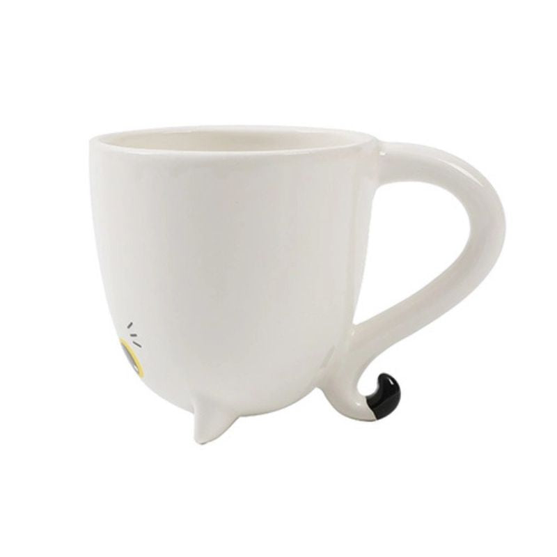 Caneca de cerâmica branca com design de gato, mostrando a pega em forma de cauda curva.