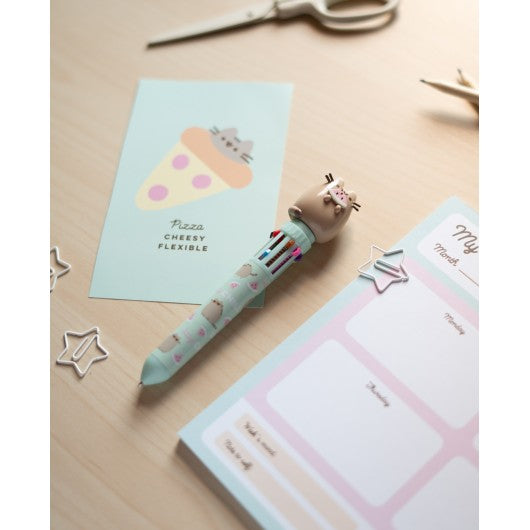 Caneta Pusheen multicolor sobre a mesa com decoração.