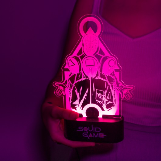 Lâmpada LED Squid Game iluminada com luz rosa, destacando o design único inspirado na série.