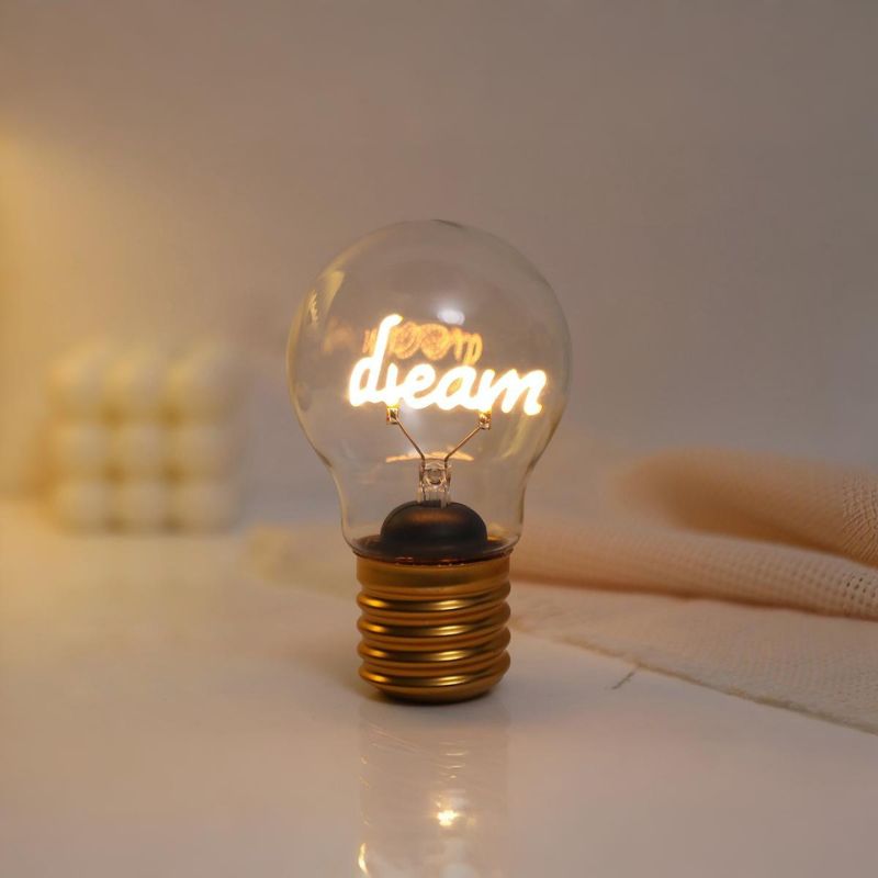 Luz Decorativa Recarregável Dream USB acesa, exibindo a palavra 'dream' em iluminação suave
