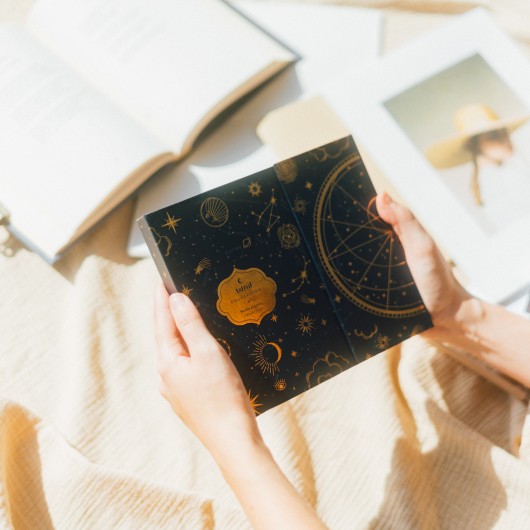 Planificador semanal astral com capa fechada e design dourado sofisticado.