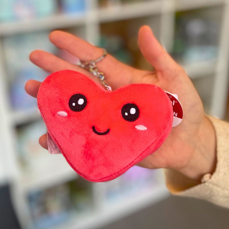 Porta-chaves em forma de coração de pelúcia vermelha com olhos brilhantes e expressão fofa seguro na mão
