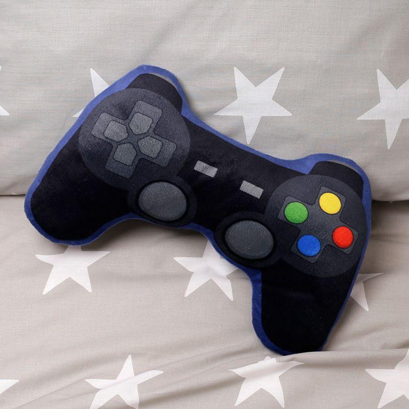 Ambiente acolhedor com almofada em forma de comando de consola Game Over em colcha cinza com estrelas