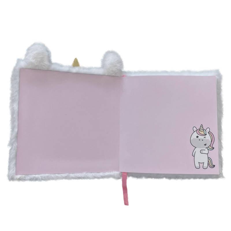Interior do caderno de pelúcia unicórnio com páginas em branco e detalhe de ilustração de um pequeno unicórnio no canto inferior direito.