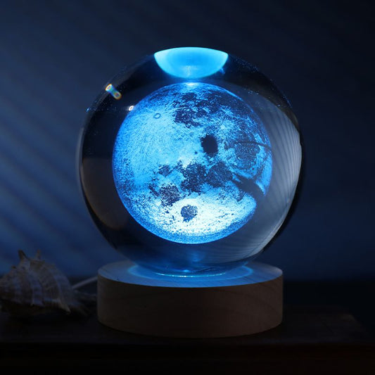 Bola de cristal lua com luz LED multicolor sobre base de madeira