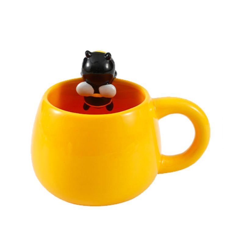 Caneca amarela com figura de abelha no interior, vista de cima