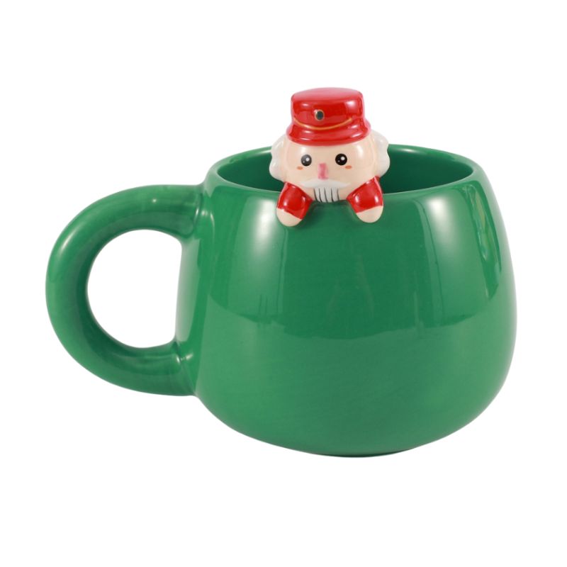 Caneca verde de Natal com figura de Quebra-Nozes no bordo