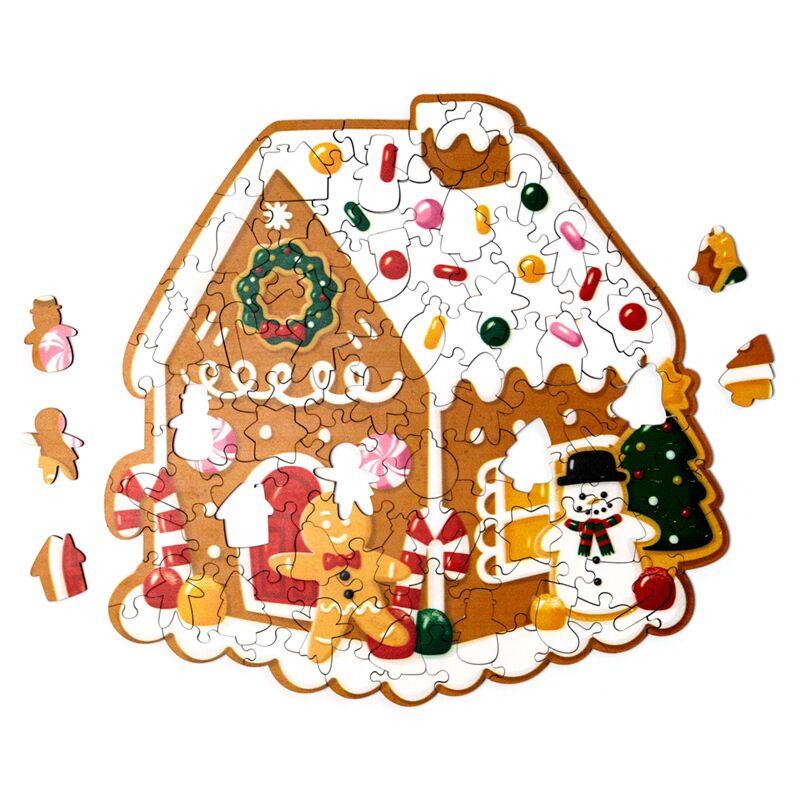 Puzzle natalício montado, casa de gengibre com boneco de neve e árvore de Natal ao fundo.